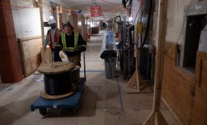 Workers transport a roll of wire through the basement hallway of Centre Block-Milenio Stadium-Canada