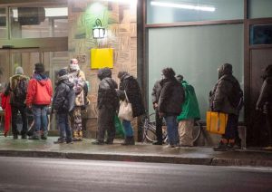 Homeless people line up outside a Montreal hotel-Milenio Stadium-Canada