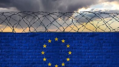 milenio stadium - brick-wall-with-barbed-wire-colors-flag-european-union-eu-against-stormy-sky-crisis-hybrid-war-border-closures-high-quality-photo