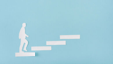 top-view-of-paper-man-on-career-ladder-on-blue-2023-11-27-05-26-47-utc